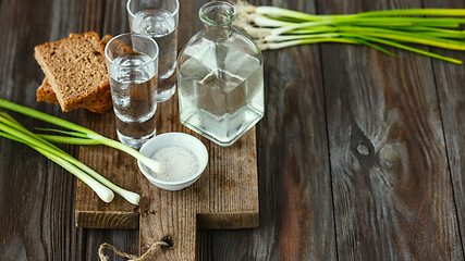 Image showing Vodka and traditional snack on wooden background