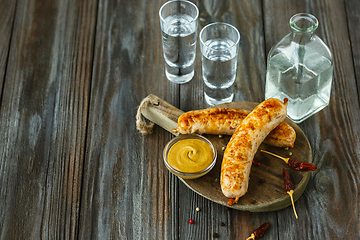 Image showing Vodka and traditional snack on wooden background