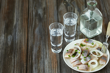 Image showing Vodka and traditional snack on wooden background