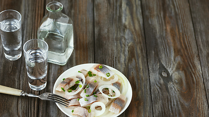 Image showing Vodka and traditional snack on wooden background