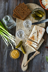 Image showing Vodka and traditional snack on wooden background