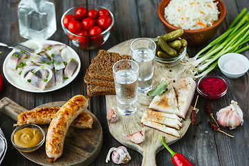 Image showing Vodka and traditional snack on wooden background