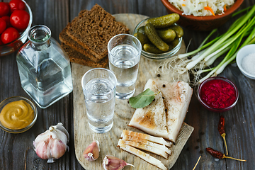 Image showing Vodka and traditional snack on wooden background