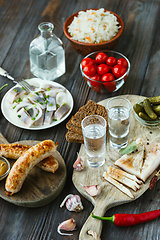 Image showing Vodka and traditional snack on wooden background