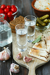 Image showing Vodka and traditional snack on wooden background