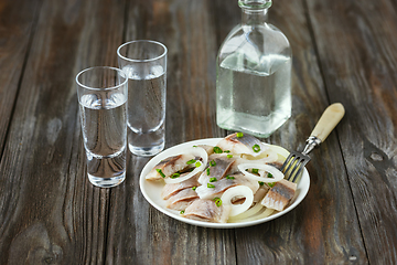 Image showing Vodka and traditional snack on wooden background