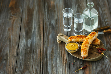 Image showing Vodka and traditional snack on wooden background