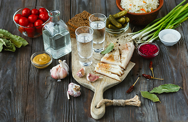 Image showing Vodka and traditional snack on wooden background