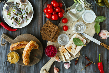 Image showing Vodka and traditional snack on wooden background