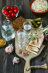 Image showing Vodka and traditional snack on wooden background