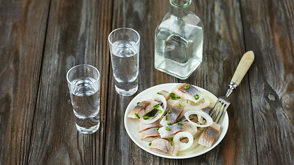 Image showing Vodka and traditional snack on wooden background