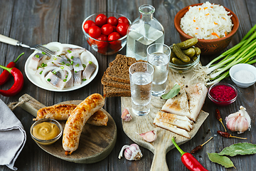 Image showing Vodka and traditional snack on wooden background