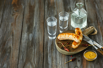 Image showing Vodka and traditional snack on wooden background