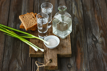 Image showing Vodka and traditional snack on wooden background