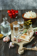 Image showing Vodka and traditional snack on wooden background