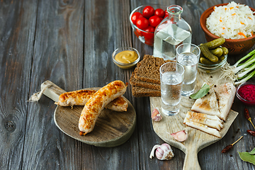 Image showing Vodka and traditional snack on wooden background