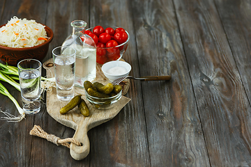 Image showing Vodka and traditional snack on wooden background