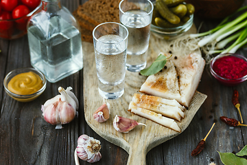 Image showing Vodka and traditional snack on wooden background