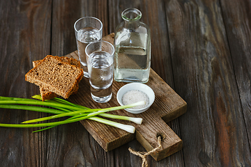 Image showing Vodka and traditional snack on wooden background