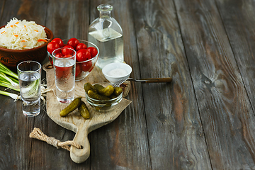 Image showing Vodka and traditional snack on wooden background