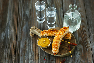 Image showing Vodka and traditional snack on wooden background