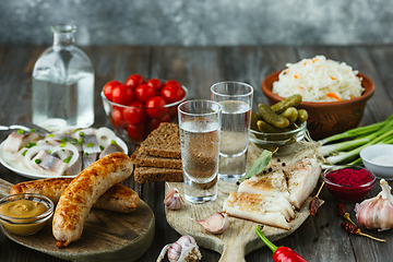 Image showing Vodka and traditional snack on wooden background