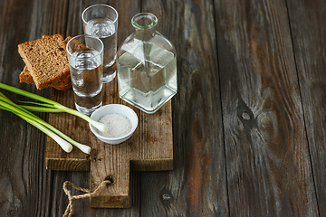 Image showing Vodka and traditional snack on wooden background