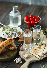 Image showing Vodka and traditional snack on wooden background