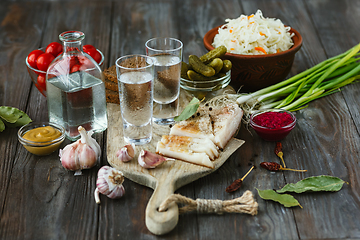 Image showing Vodka and traditional snack on wooden background