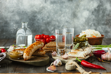 Image showing Vodka and traditional snack on wooden background