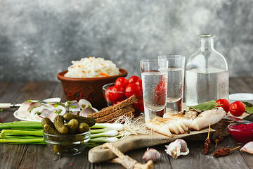 Image showing Vodka and traditional snack on wooden background