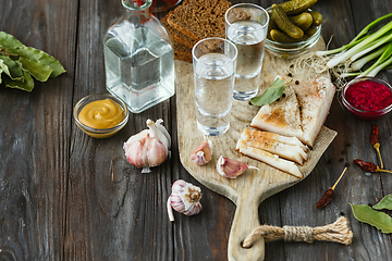 Image showing Vodka and traditional snack on wooden background