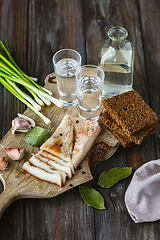 Image showing Vodka and traditional snack on wooden background