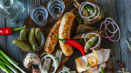 Image showing Vodka and traditional snack on wooden background