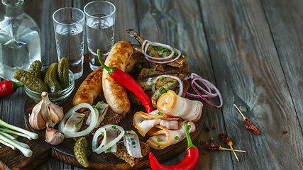 Image showing Vodka and traditional snack on wooden background