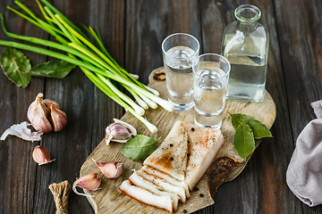 Image showing Vodka and traditional snack on wooden background