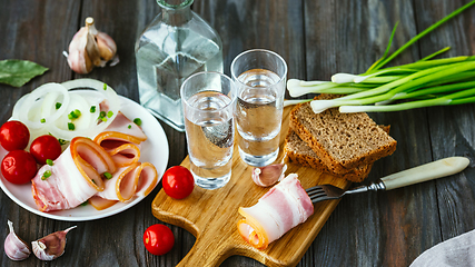 Image showing Vodka and traditional snack on wooden background