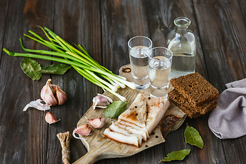 Image showing Vodka and traditional snack on wooden background