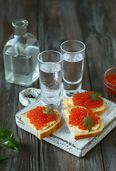 Image showing Vodka and traditional snack on wooden background