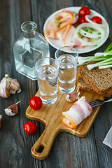 Image showing Vodka and traditional snack on wooden background