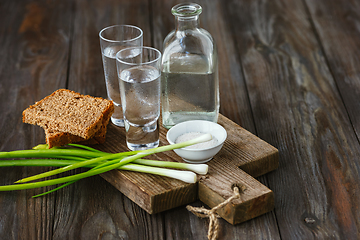 Image showing Vodka and traditional snack on wooden background