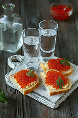 Image showing Vodka and traditional snack on wooden background