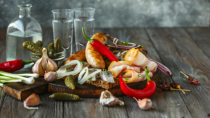 Image showing Vodka and traditional snack on wooden background