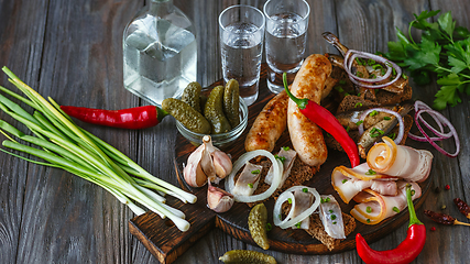 Image showing Vodka and traditional snack on wooden background