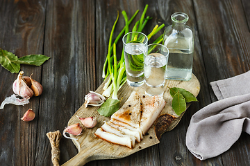 Image showing Vodka and traditional snack on wooden background