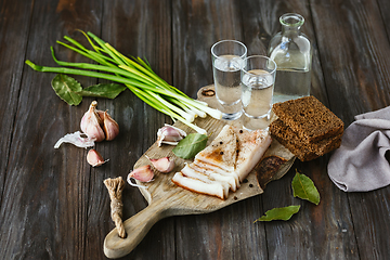 Image showing Vodka and traditional snack on wooden background