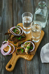 Image showing Vodka and traditional snack on wooden background