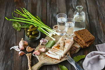 Image showing Vodka and traditional snack on wooden background