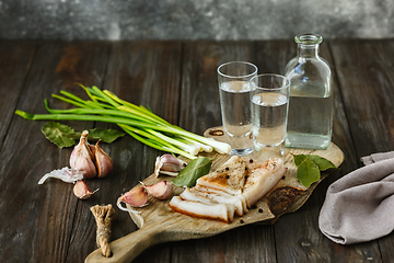 Image showing Vodka and traditional snack on wooden background