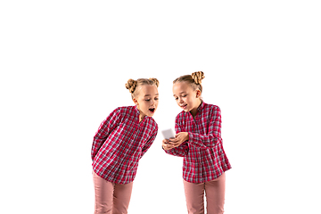 Image showing Young handsome girl arguing with herself on white studio background.